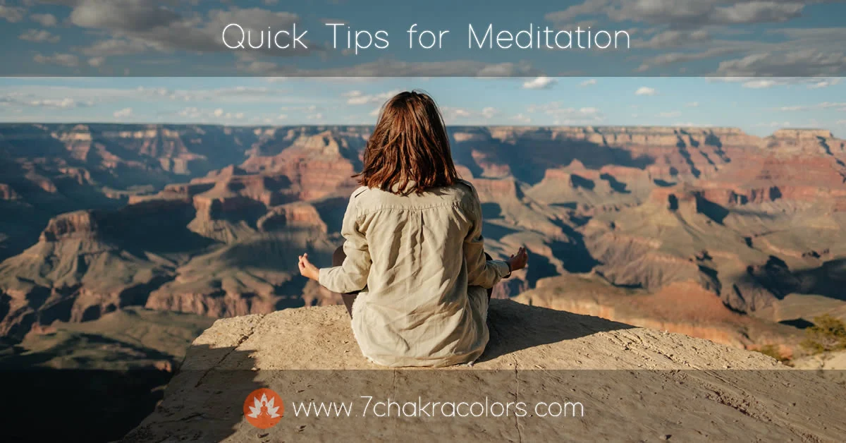 woman sitting in meditation pose on top of the mountain overlooking a canyon
