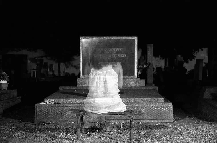 Ghost sitting on a grave.