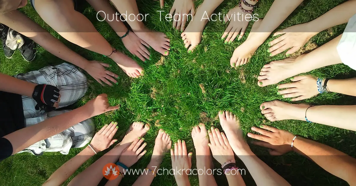 a group of people's feet an d hands in a circle in the grass
