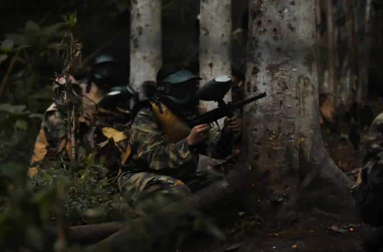 a group of people in camouflage holding a paintball gun