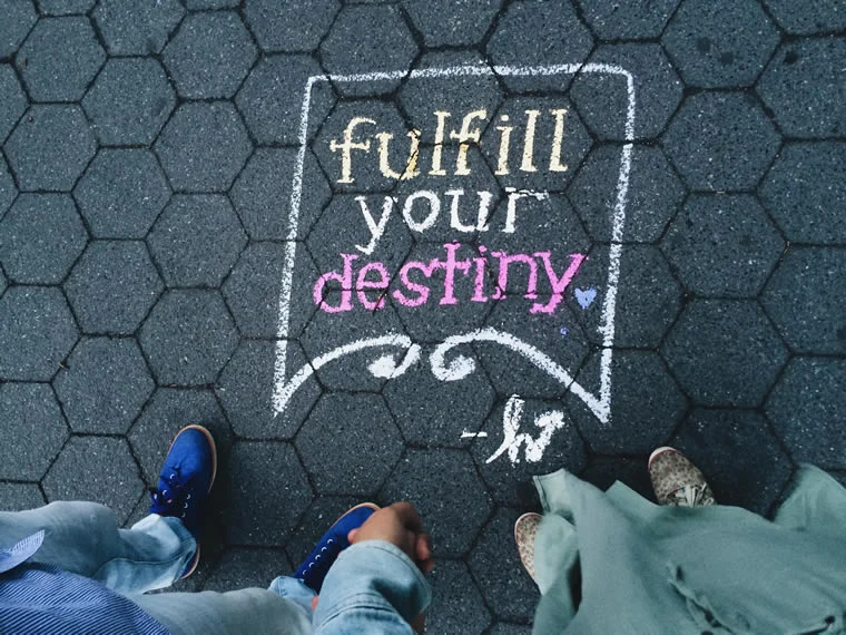 a person's legs and a sign on a pavement