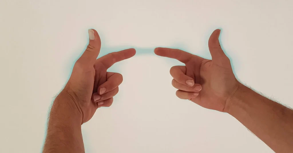two hands pointing index fingers at each other with pale blue aura around them
